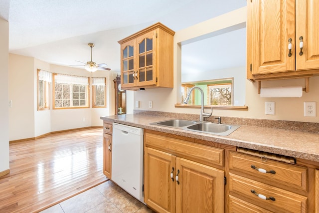 kitchen featuring ceiling fan, a sink, glass insert cabinets, dishwasher, and light wood-type flooring