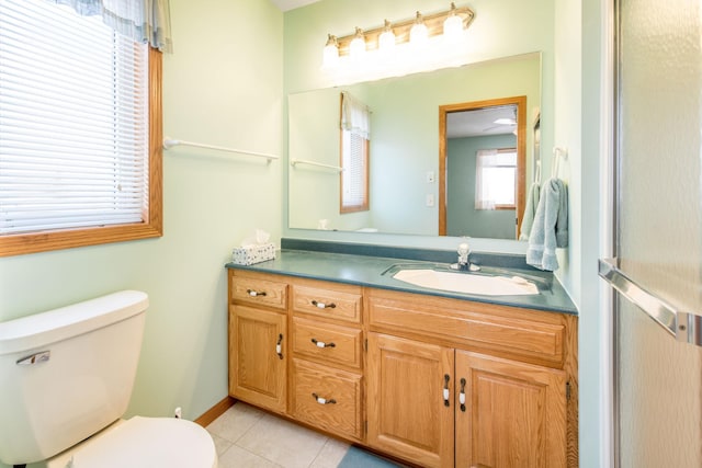 bathroom with tile patterned floors, toilet, vanity, and baseboards