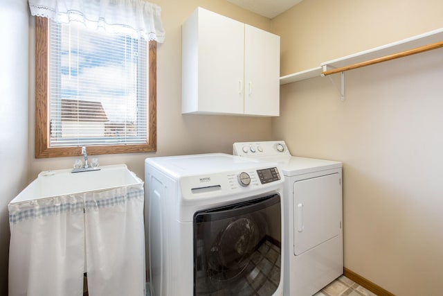 clothes washing area featuring cabinet space, independent washer and dryer, and baseboards