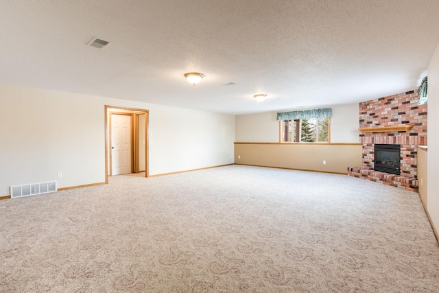 unfurnished living room featuring carpet flooring, a fireplace, visible vents, and a textured ceiling