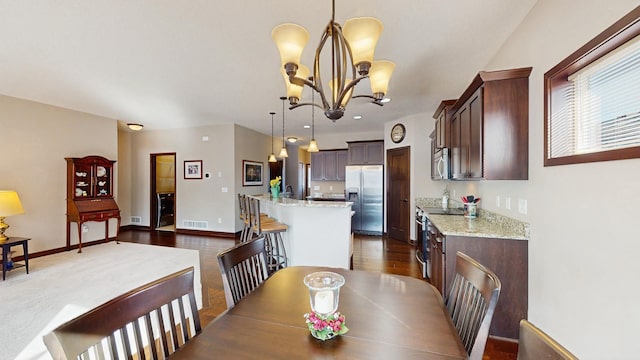 dining room with dark wood finished floors, a notable chandelier, baseboards, and visible vents