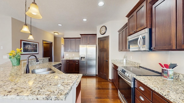 kitchen featuring dark wood finished floors, pendant lighting, recessed lighting, appliances with stainless steel finishes, and a sink