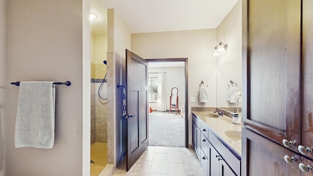 bathroom with a sink, walk in shower, double vanity, and tile patterned floors