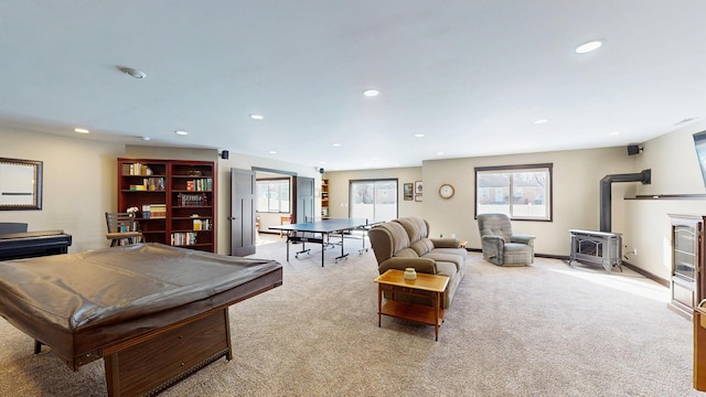 rec room featuring baseboards, light colored carpet, recessed lighting, a wood stove, and billiards