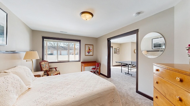 bedroom featuring visible vents, light colored carpet, and baseboards