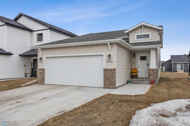 view of front of home with an attached garage, brick siding, driveway, and a shingled roof