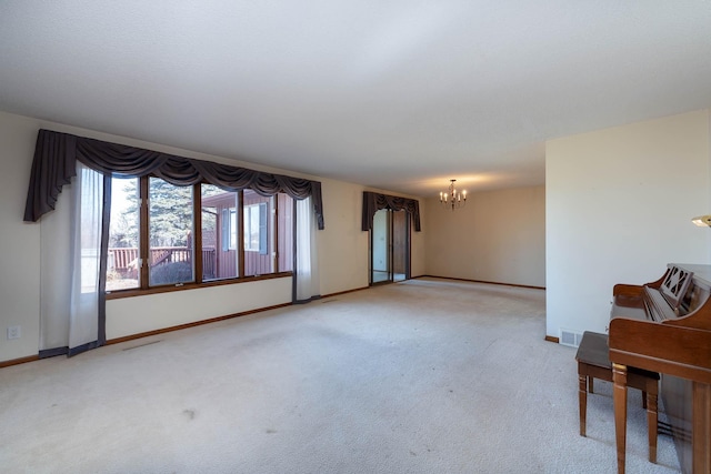 spare room with a notable chandelier, baseboards, and carpet floors