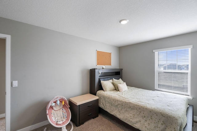 carpeted bedroom featuring baseboards and a textured ceiling