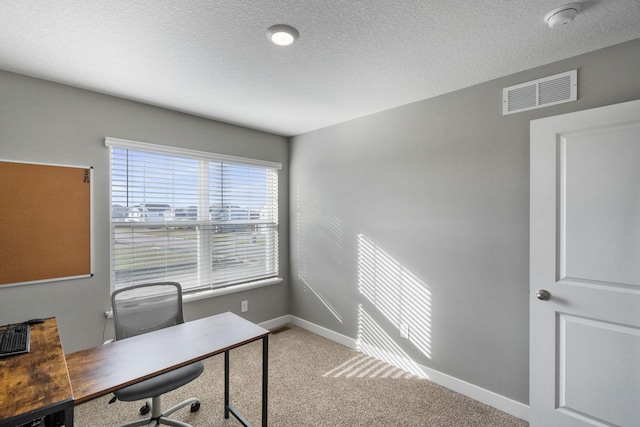 carpeted office space with a textured ceiling, visible vents, and baseboards