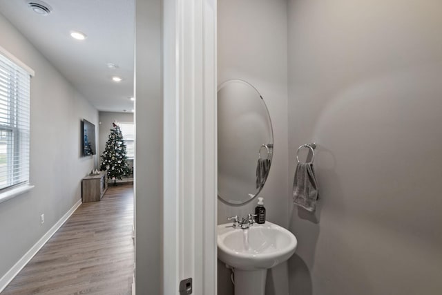 bathroom featuring a sink, wood finished floors, a wealth of natural light, and baseboards