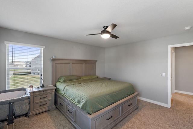 bedroom featuring baseboards, a ceiling fan, and light colored carpet