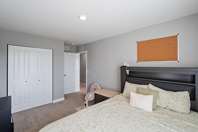 bedroom with a textured ceiling, a closet, carpet, and visible vents