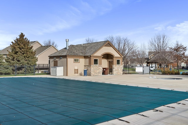 community pool with a patio and fence