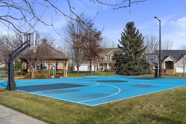 view of basketball court with community basketball court and a lawn