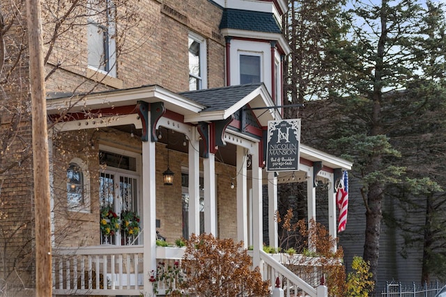 view of property exterior with brick siding and roof with shingles