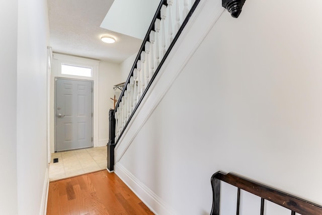 entrance foyer featuring stairway, baseboards, and light wood-style floors