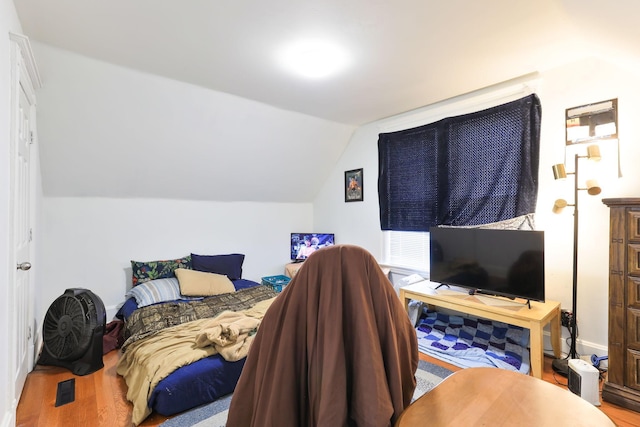 bedroom featuring visible vents, lofted ceiling, and wood finished floors