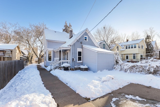 view of front of property featuring a residential view, a chimney, a garage, and fence