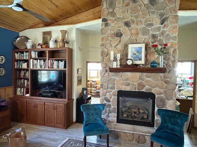 living area featuring a fireplace, wood ceiling, vaulted ceiling, wainscoting, and light wood finished floors