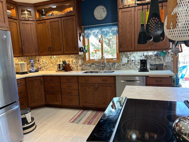 kitchen with stainless steel appliances, a sink, and light countertops