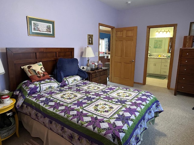 carpeted bedroom featuring baseboards and connected bathroom