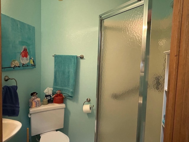 full bath featuring a stall shower and toilet