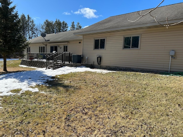 back of house featuring central air condition unit, a lawn, and a wooden deck