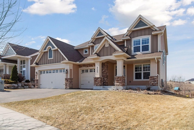 craftsman house with a garage, board and batten siding, aphalt driveway, and stone siding