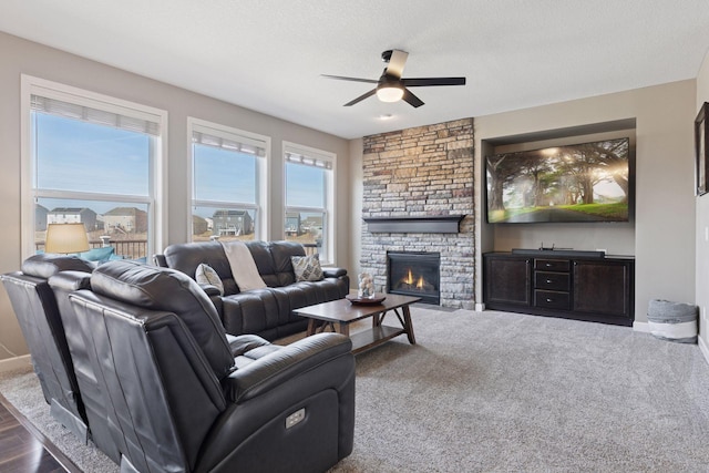 living room with baseboards, a fireplace, and a ceiling fan