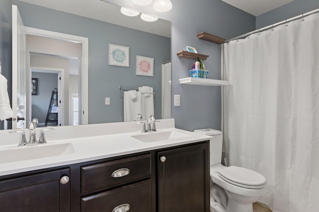 full bathroom with double vanity, a sink, and toilet