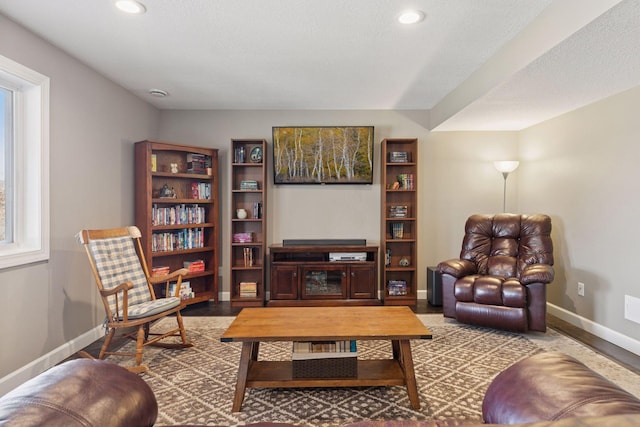 living area featuring baseboards and recessed lighting