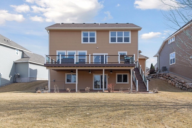 back of property with a deck, ceiling fan, a yard, and stairway
