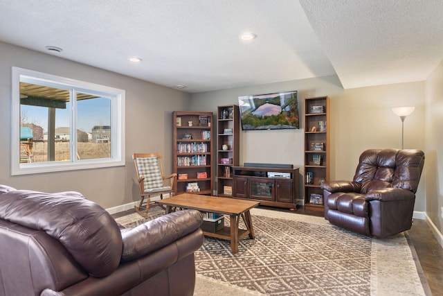 living area featuring a textured ceiling, baseboards, and recessed lighting