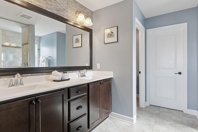 4520 Bailey Lake Dr, Woodbury, MN 55129 - full bathroom with double vanity, baseboards, a tile shower, and tile patterned flooring
