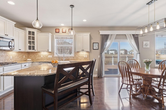 4520 Bailey Lake Dr, Woodbury, MN 55129 - kitchen featuring stainless steel appliances, recessed lighting, backsplash, a breakfast bar area, and white cabinets