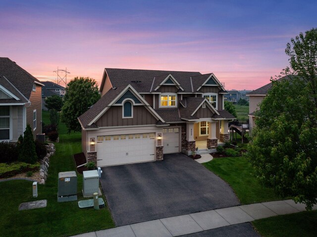 4520 Bailey Lake Dr, Woodbury, MN 55129 - view of front of house featuring board and batten siding, stone siding, asphalt driveway, and a lawn
