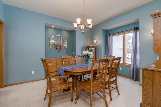 dining space featuring visible vents, baseboards, a chandelier, light colored carpet, and a textured ceiling