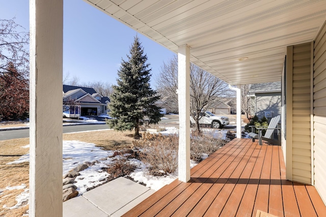 snow covered deck featuring covered porch