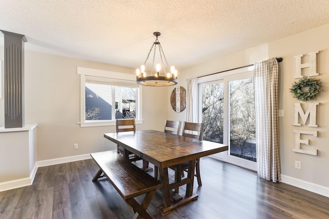 dining area with a notable chandelier, dark wood-style floors, baseboards, and a textured ceiling