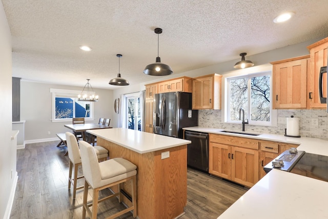 kitchen featuring backsplash, a center island, stainless steel fridge with ice dispenser, dishwashing machine, and a sink