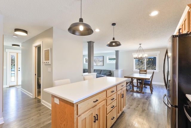 kitchen with a wealth of natural light, light wood-type flooring, a center island, and freestanding refrigerator