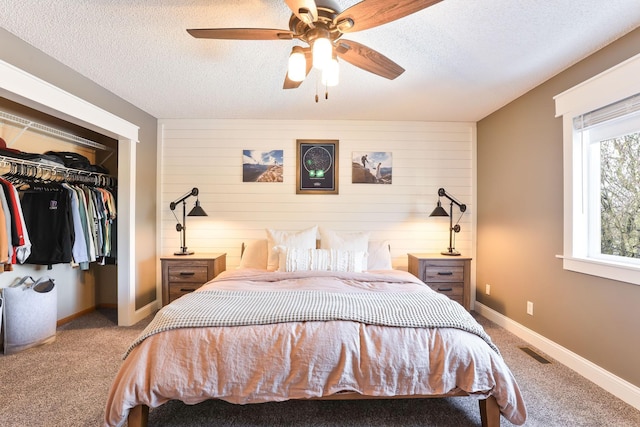 carpeted bedroom with ceiling fan, baseboards, visible vents, and a textured ceiling