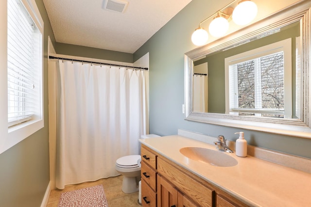 bathroom with vanity, toilet, plenty of natural light, and visible vents