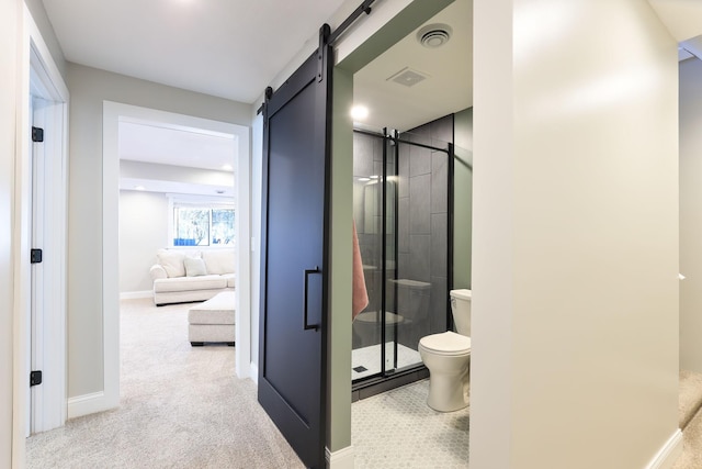 ensuite bathroom with a stall shower, toilet, visible vents, and connected bathroom