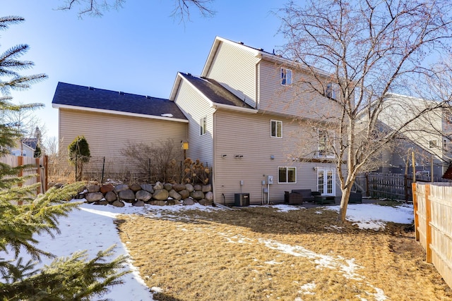 back of property featuring french doors, central AC, and a fenced backyard