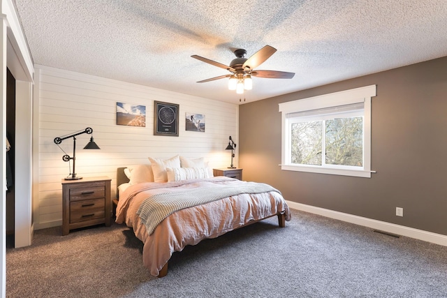 carpeted bedroom with ceiling fan, baseboards, visible vents, and a textured ceiling