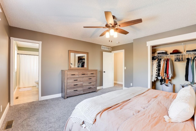 carpeted bedroom with visible vents, baseboards, a textured ceiling, and a closet