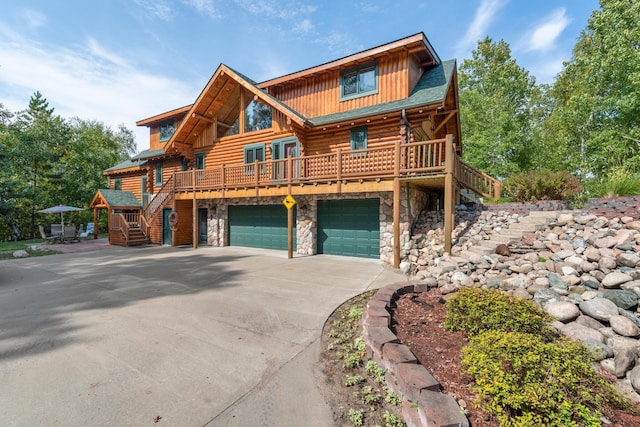 log cabin featuring a garage, stone siding, concrete driveway, stairway, and log exterior