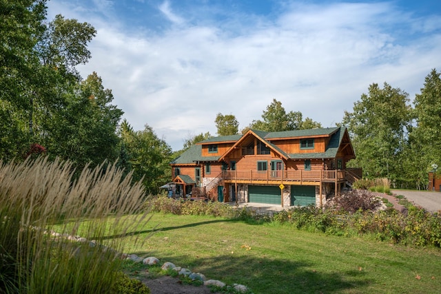 back of house featuring a deck, a garage, stairs, stone siding, and a lawn