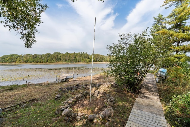 view of dock featuring a water view and a wooded view